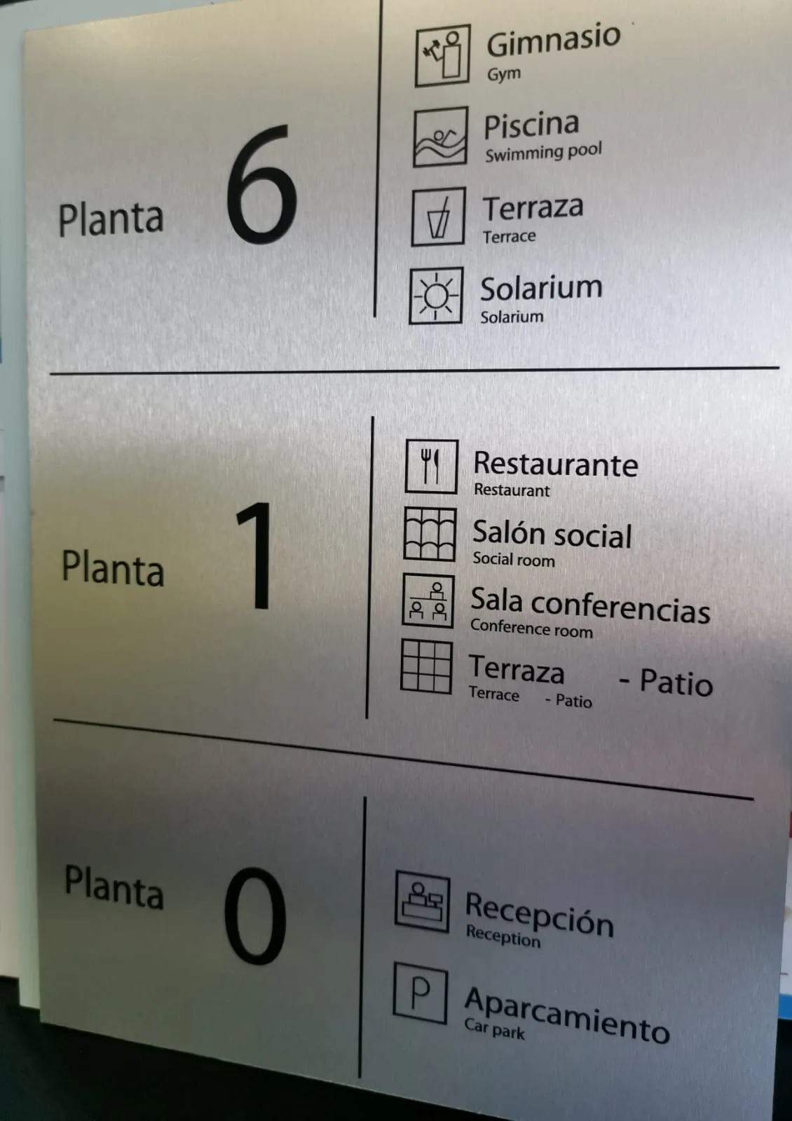 Directorio de plantas con pictogramas en vinilo de corte negro sobre panel de aluminio cepillado