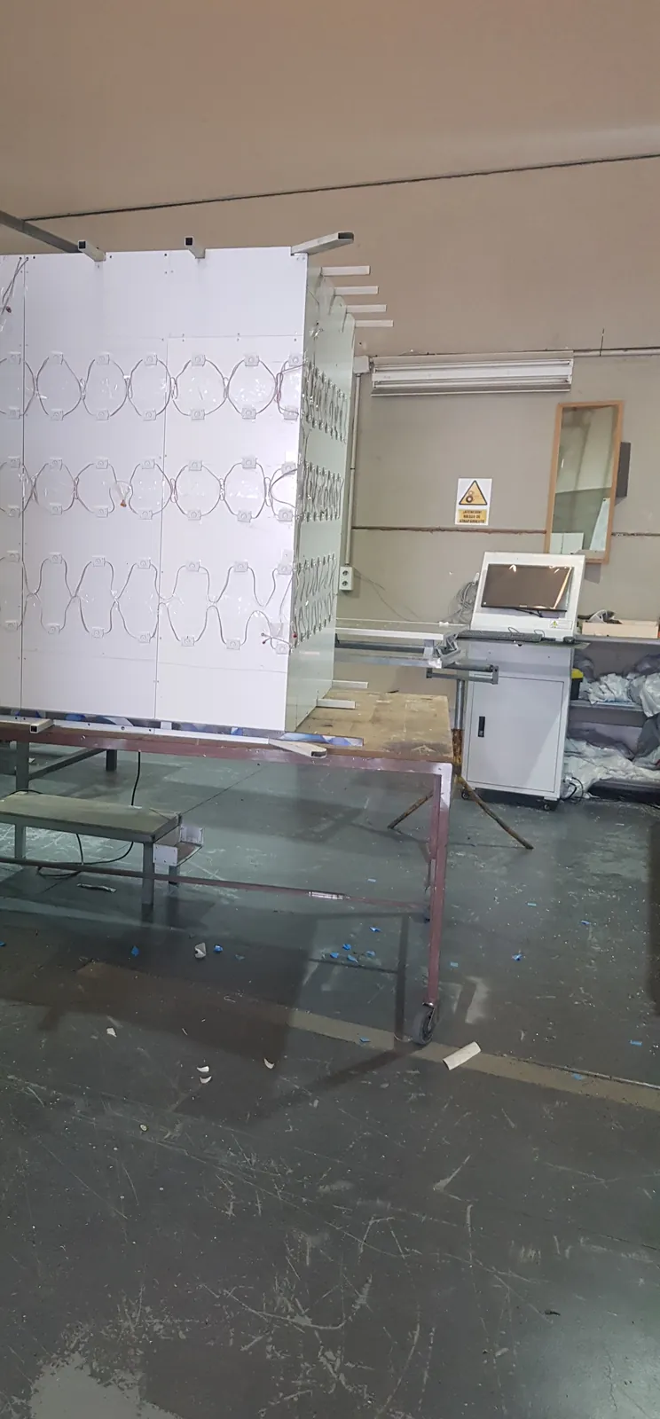 Caja de luz de gran formato en fabricación en el taller, con módulos LED cableados sobre paneles blancos y estructura de tubo de acero