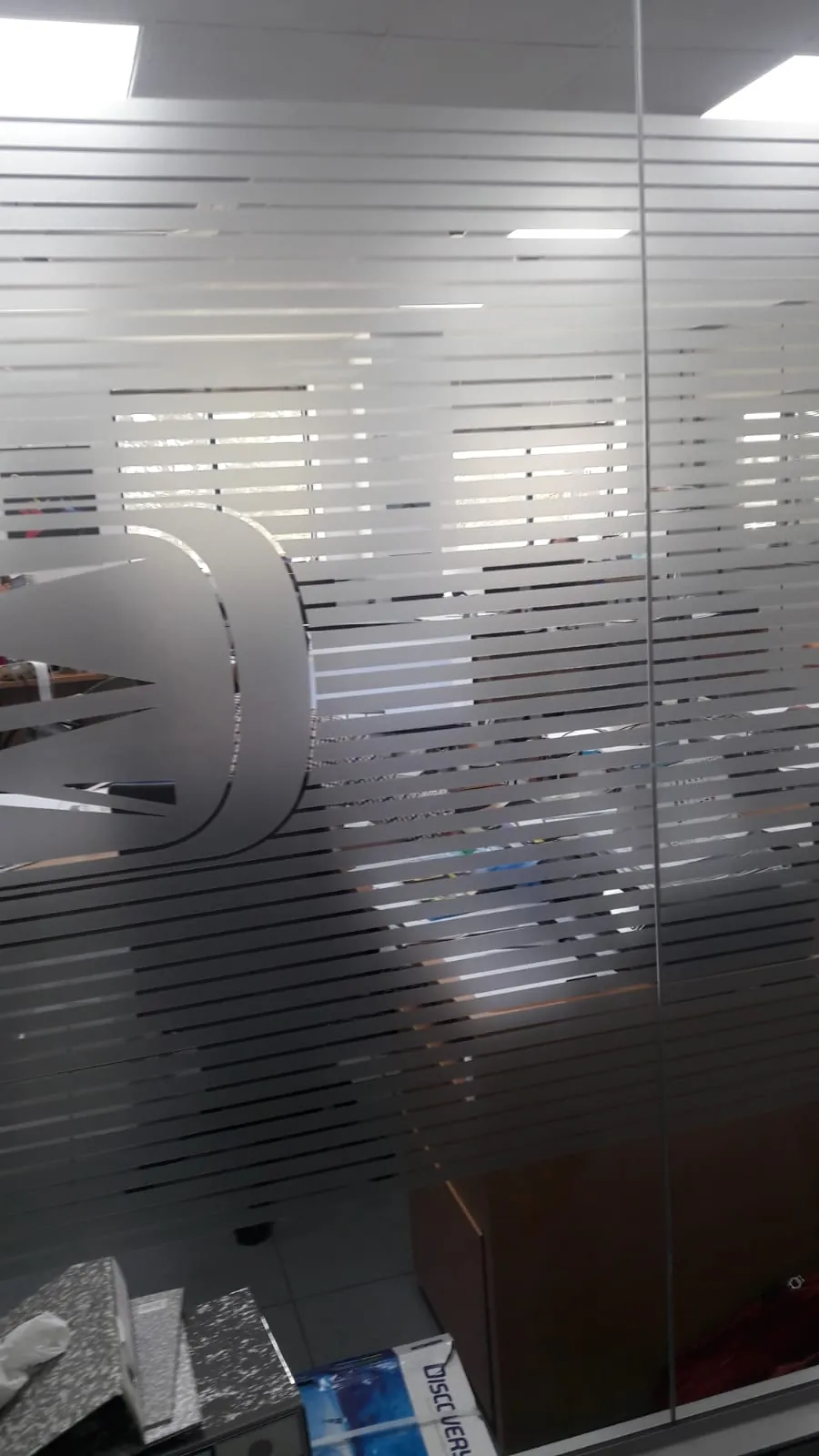 Vinilo ácido a franjas en una mampara acristalada de oficina